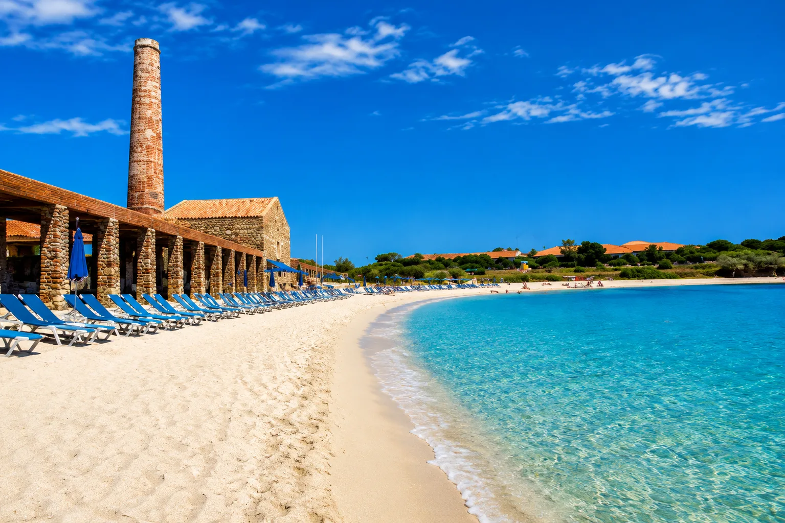 Le Tonnare, Stintino — spiaggia di sabbia chiara con acqua cristallina davanti all'antica tonnara in pietra