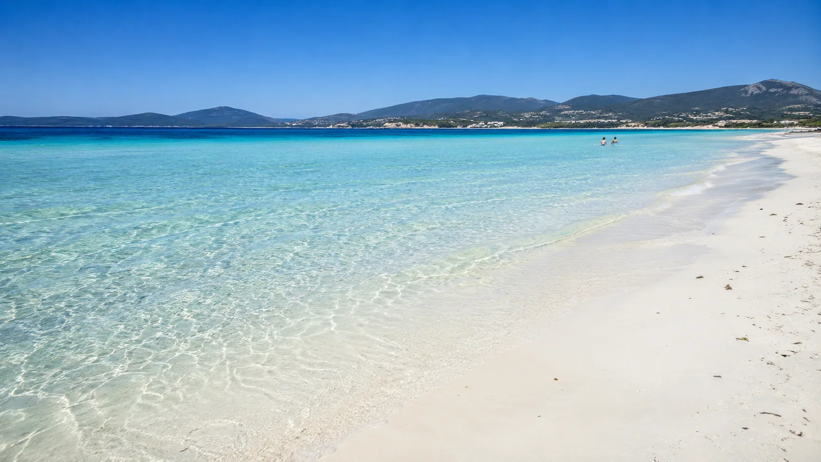 Maria Pia, Alghero — sabbia bianchissima e acqua trasparente con vista sulle colline di Capo Caccia