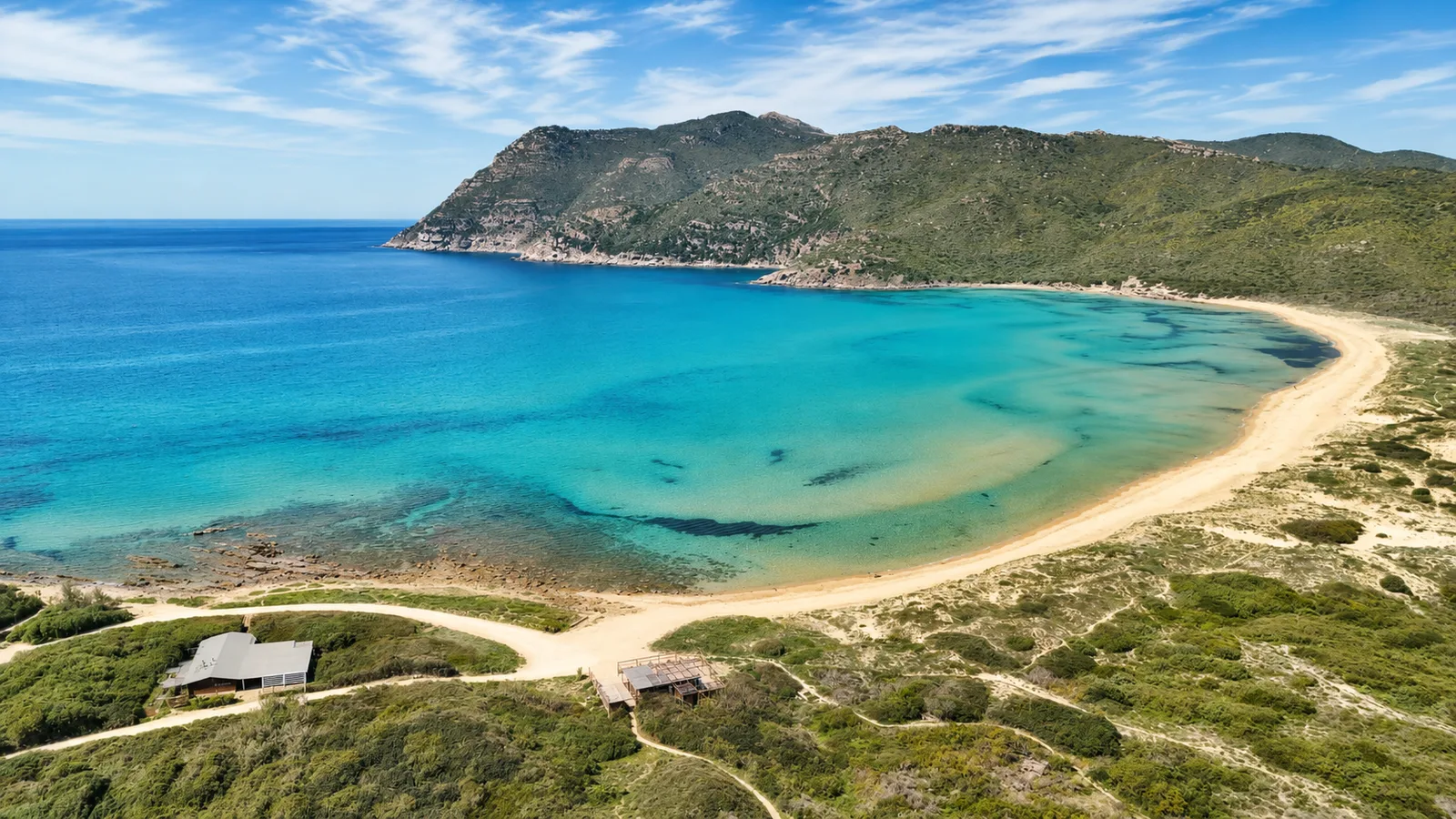 Porto Ferro, Sassari — baia ampia con sabbia dorata, mare trasparente e promontorio verde
