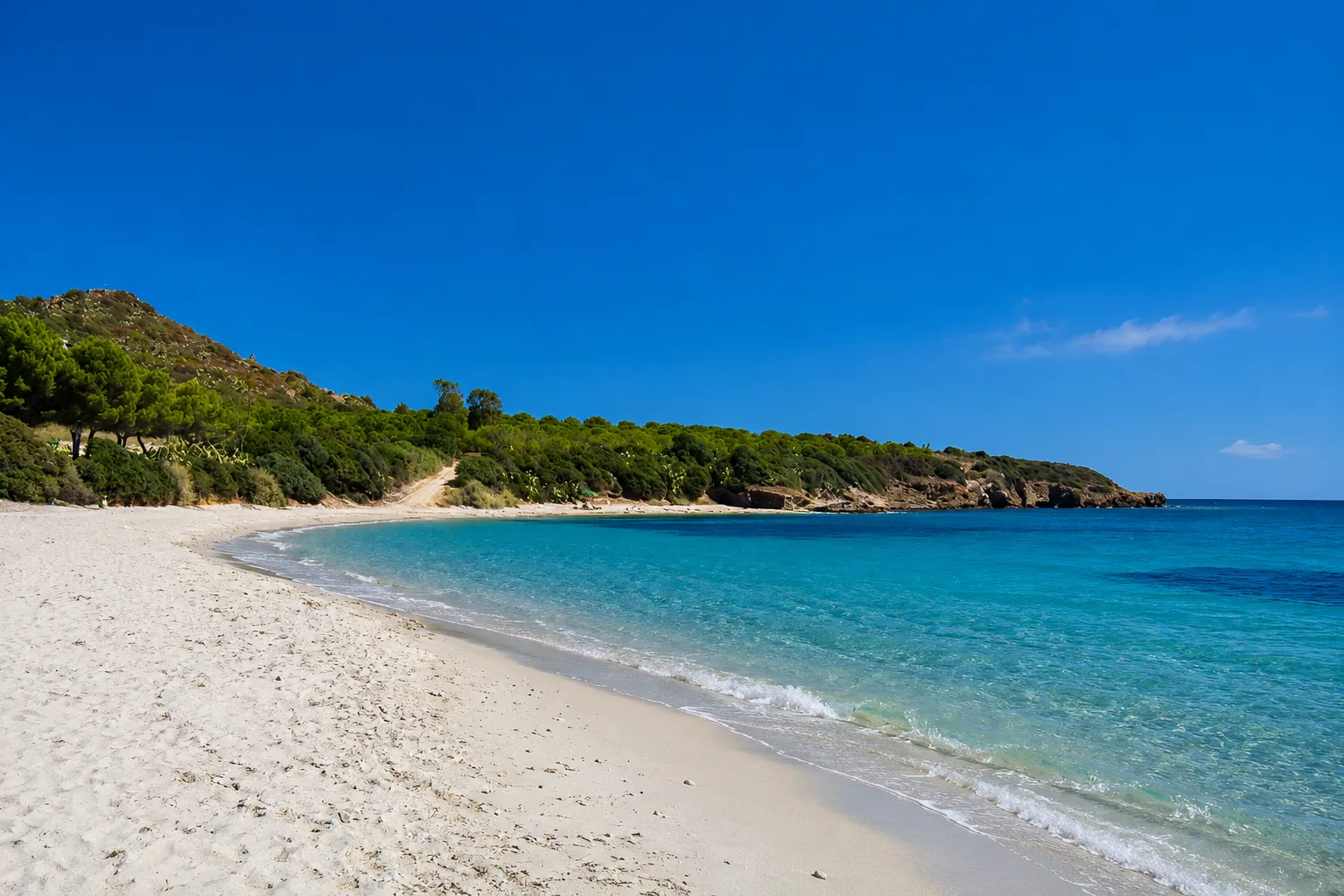 Su Guventeddu, Pula — spiaggia di sabbia bianca con mare turchese e promontorio verde