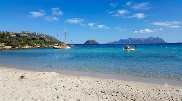 Baia Caddinas, Golfo Aranci — sabbia bianca fine e acqua turchese con Tavolara e Figarolo sullo sfondo