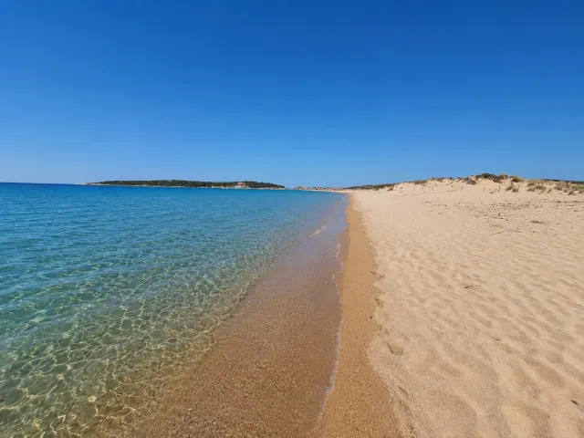 Barrabisa, Palau — spiaggia di sabbia dorata con dune, acqua trasparente e vista sulle isole