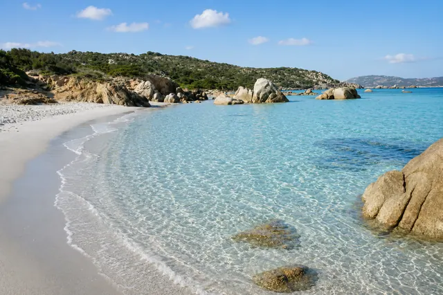 Spiaggia Bassa Trinita, La Maddalena — arenile bianchissimo con acqua trasparente e bassi fondali tra i graniti dell'arcipelago