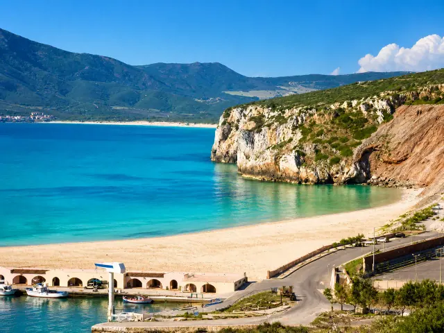 Buggerru — baia con porticciolo e sabbia chiara sotto la falesia