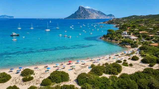 Cala Girgolu, San Teodoro — baia con sabbia chiara, barche all'ancora e vista su Tavolara
