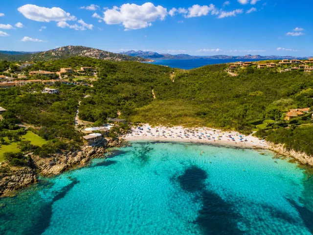 Cala Granu, Arzachena — piccola baia turchese incorniciata dalla macchia mediterranea e dalle ville sul promontorio