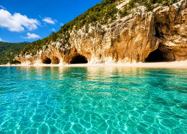Cala Luna, Baunei/Dorgali — mezzaluna di sabbia chiara con grotte naturali nelle falesie calcaree