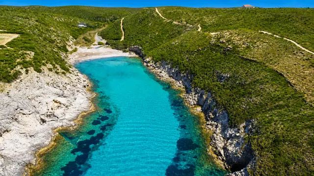 Cala Lunga, Sant'Antioco — stretta insenatura turchese tra falesie calcaree e macchia mediterranea