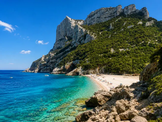 Cala Sisine, Baunei — ampia cala di ciottoli chiari tra alte falesie calcaree e mare turchese