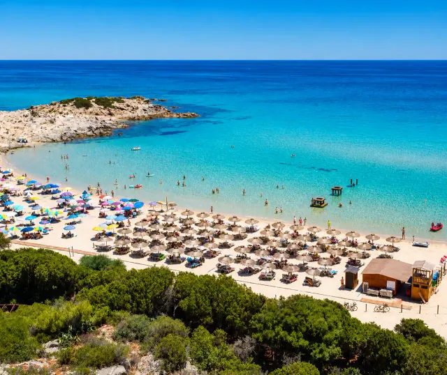 Spiaggia Campana, Domus de Maria — baia con sabbia bianchissima, ombrelloni e acqua turchese cristallina