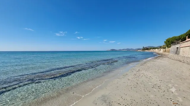 Capitana, Quartu Sant'Elena — arenile stretto di sabbia chiara con acqua cristallina e muretti in pietra sul lungomare