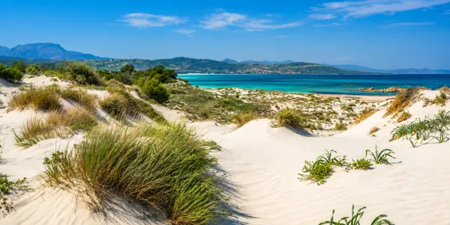 Capo Comino, Siniscola — dune bianche, ginepri e mare turchese con vista aperta sulla costa