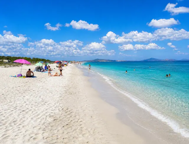Ezzi Mannu, Stintino — lunga spiaggia chiara con mare turchese e orizzonte aperto verso l'Asinara