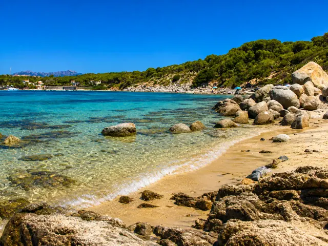 Is Mortorius, Quartu Sant'Elena — cala con scogli granitici, sabbia chiara e acqua turchese cristallina