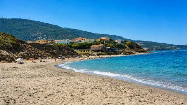 La Ciaccia, Valledoria — spiaggia di sabbia scura vulcanica amata dai surfisti con mare blu intenso