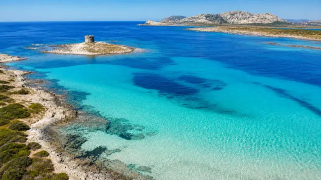 La Pelosa, Stintino — acqua turchese cristallina con torre aragonese e isola dell'Asinara