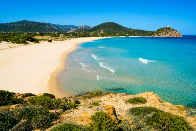 Cala Malfatano, Teulada — ampia baia con sabbia dorata, mare turchese e torre spagnola sul promontorio
