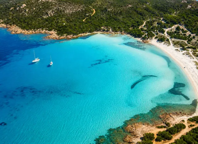 Piccolo Pevero, Arzachena — vista aerea della cala con acqua trasparente e barche all'ancora