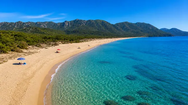 Portixeddu, Fluminimaggiore — lunga spiaggia dorata con monte sullo sfondo
