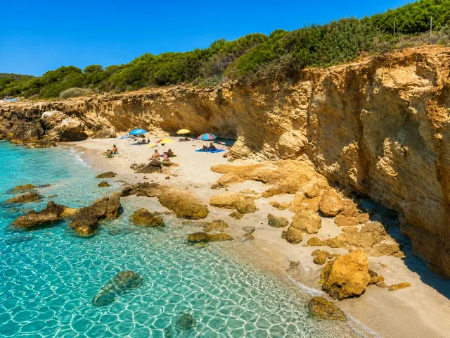 Porto Pinetto, Sant'Anna Arresi — caletta riparata tra falesie dorate, sabbia chiara e acqua turchese cristallina