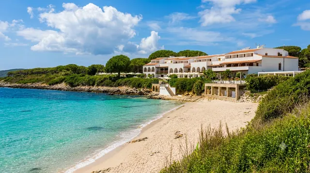 Punta Negra, Alghero — spiaggia di sabbia chiara con acqua turchese trasparente, resort sul promontorio e macchia mediterranea