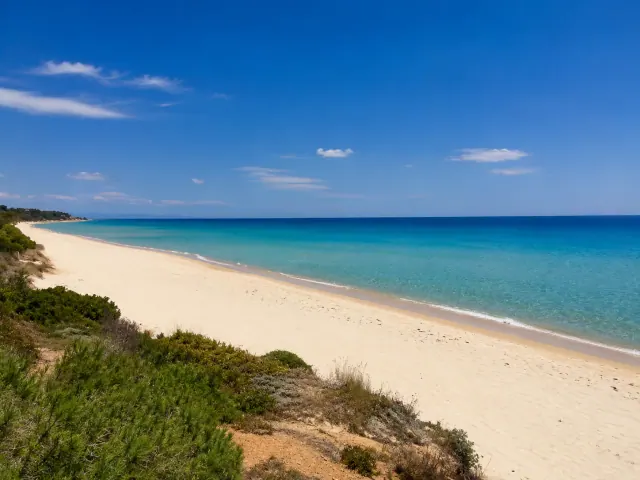 Santa Margherita di Pula — lunga spiaggia di sabbia chiara con mare turchese e macchia mediterranea