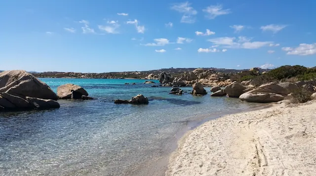 Spiaggia dello Strangolato, La Maddalena — sabbia chiara con grandi massi granitici, acqua turchese cristallina e macchia mediterranea