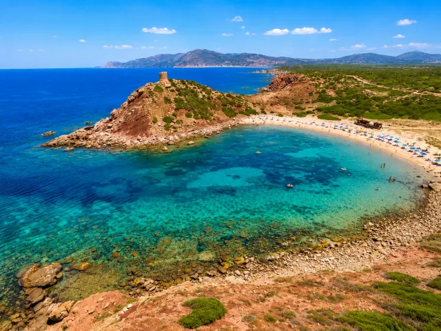 Torre del Porticciolo, Alghero — vista aerea della baia turchese con torre aragonese sul promontorio rosso