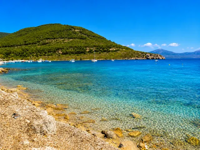 Tramariglio, Alghero — cala riparata dentro Porto Conte con acqua trasparente e barche all'ancora